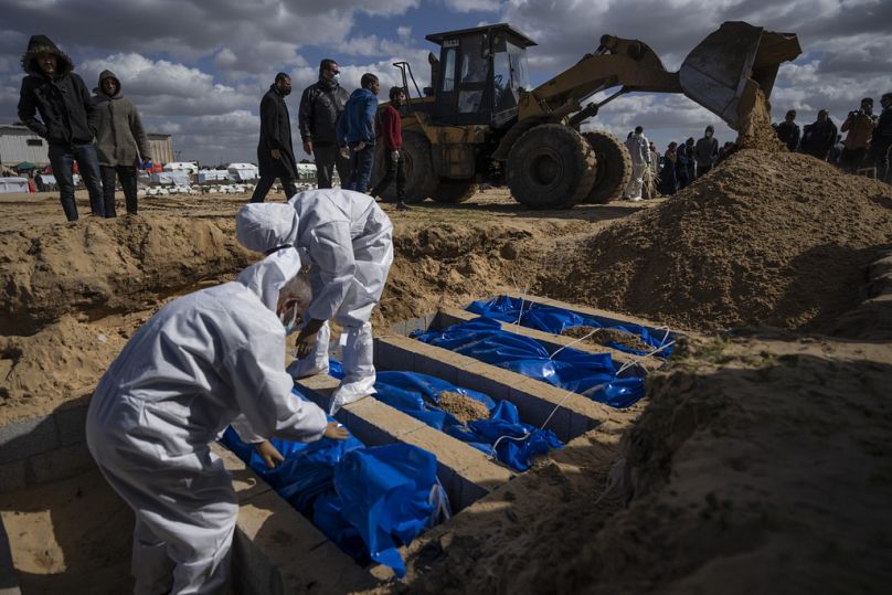 Les Palestiniens enterrent les corps des personnes tuées dans les combats avec Israël et ramenées à Gaza par l'armée israélienne, lors de funérailles de masse à Rafah, dans la bande de Gaza.