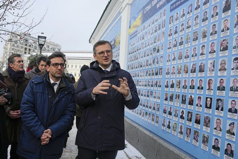 Le ministre ukrainien des Affaires étrangères Dmytro Kuleba, à droite, et son homologue français Stéphane Séjourne, au centre à gauche, visitent le Mur de la mémoire des défenseurs ukrainiens tombés au combat à Kiev