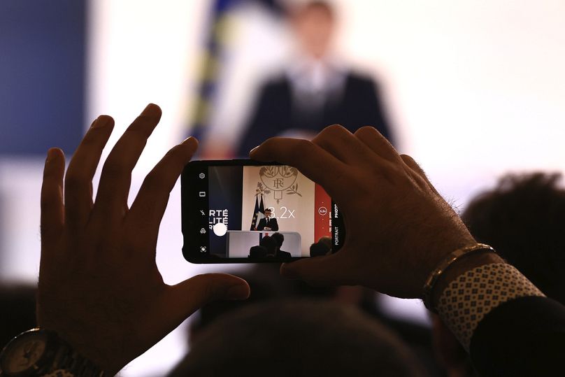 Un journaliste prend une photo du président français Emmanuel Macron le mardi 16 janvier 2024 à l'Elysée à Paris.