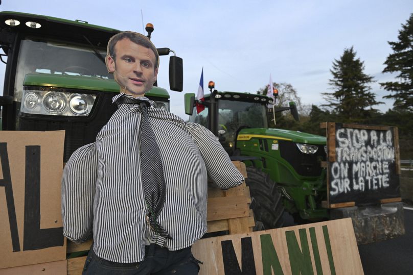 Une effigie du président français Emmanuel Macron est vue sur un tracteur alors que des agriculteurs manifestent sur une autoroute, le lundi 29 janvier 2024.