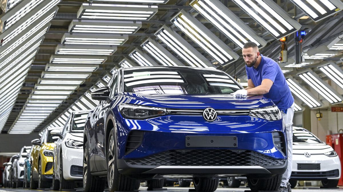 This Sept. 18, 2020 file photo shows an employee putting finishing touches to a battery-powered VW ID.4 at the Volkswagen plant in Zwickau, Germany.
