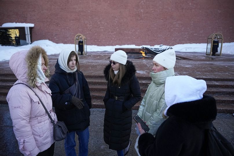 Les épouses de soldats russes mobilisés pour combattre en Ukraine se parlent après avoir déposé des fleurs sur la tombe du Soldat inconnu, près du mur du Kremlin à Moscou, en Russie.