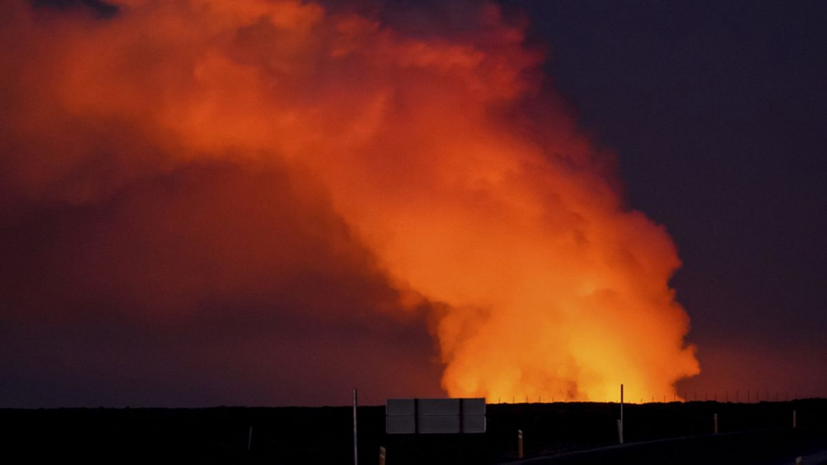 A view of the plume of gas lighted up by the lava from the erupting volcano seen from Suðurstrandavegur, the road that leads to Grindavík, Iceland, Sunday Jan. 14, 2024