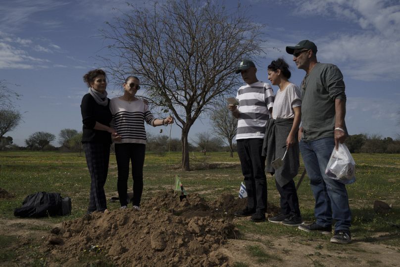 Amis et parents prient avant de planter un arbre à la mémoire de la personne tuée le 7 octobre lors d'une attaque transfrontalière du Hamas au festival de musique Nova.