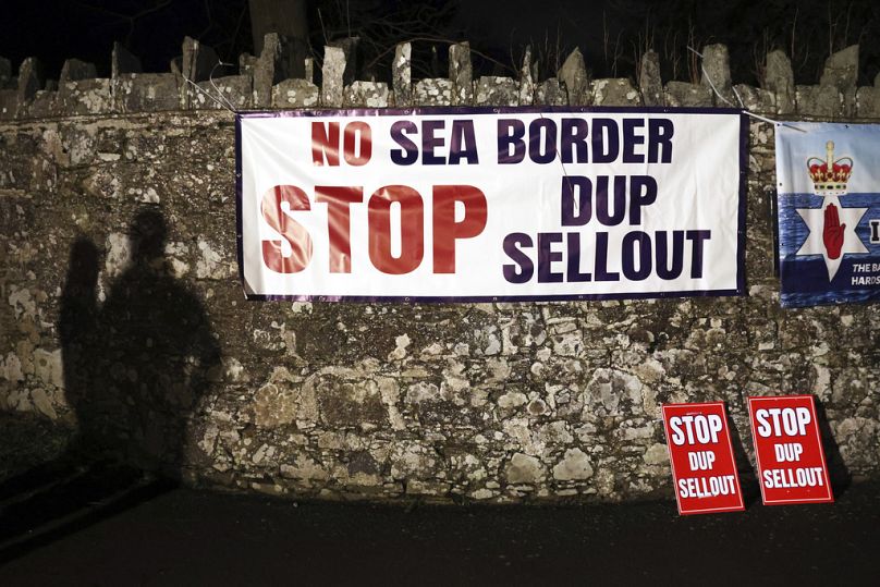 Une ombre de manifestants loyalistes est visible sur le mur à l'extérieur du terrain où se déroule la réunion exécutive du Parti unioniste démocratique à Larchfield Estate à Lisburn.