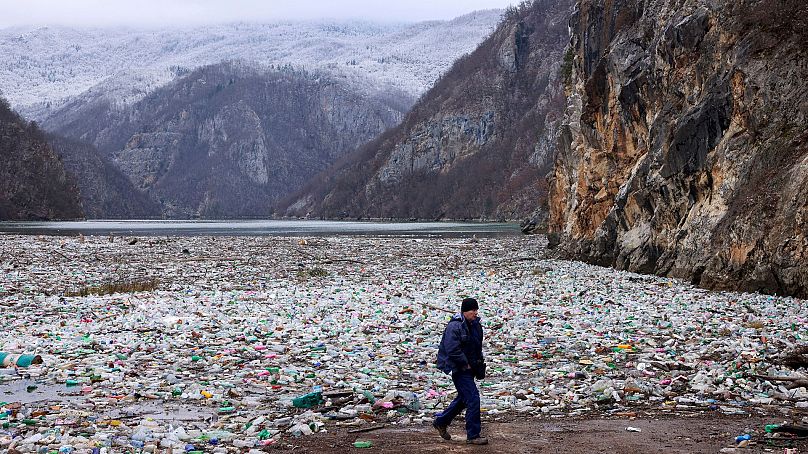 Un grutier marche à côté de la base de déchets dans la rivière Drina, près de Visegrad, en Bosnie, le 10 janvier 2024.