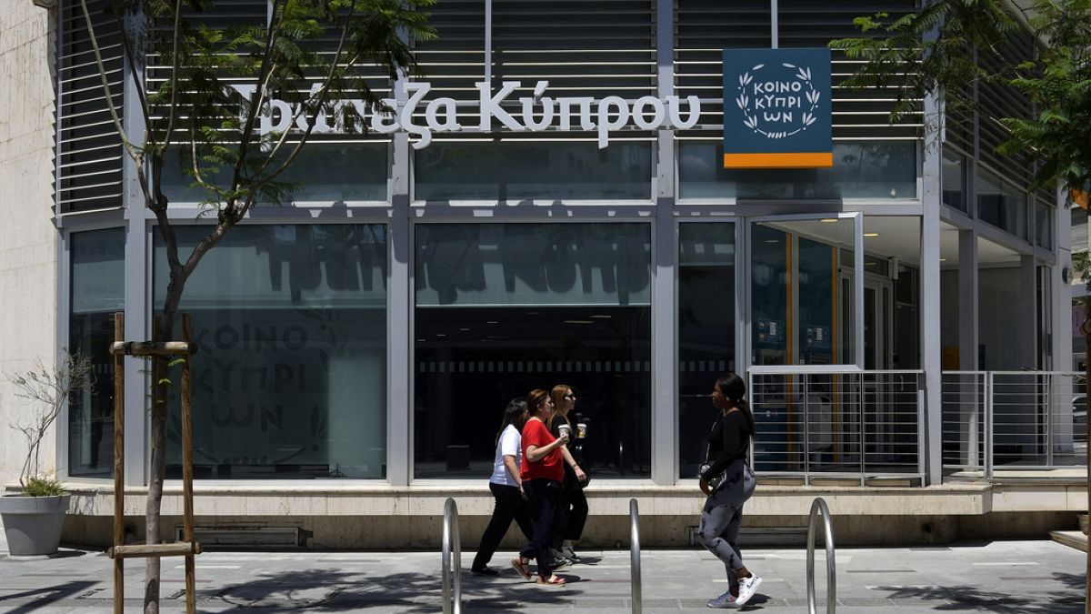 Women walk outside of a branch of Bank of Cyprus at a main shopping street in capital Nicosia, Cyprus in 2023