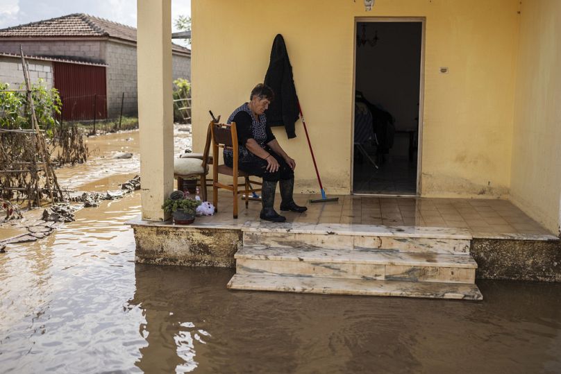 Une femme prend une pause pour nettoyer sa maison inondée dans le village de Sotirio, près de la ville de Volos, en Grèce, le vendredi 29 septembre 2023.