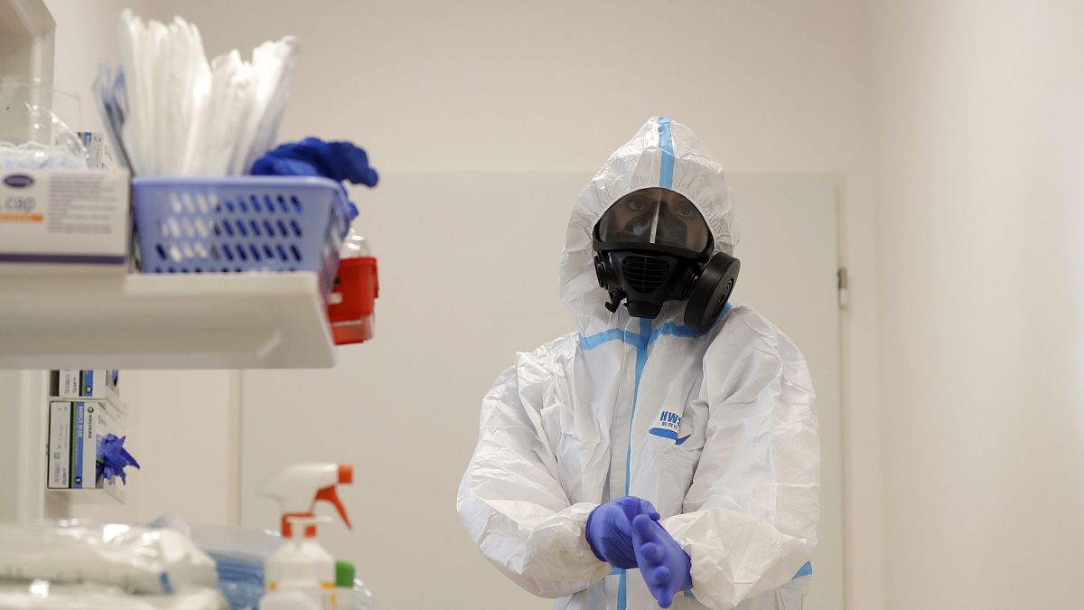 A health care worker dresses up in personal protective equipment (PPE) before tending to COVID-19 patients in a hospital in the Czech Republic.