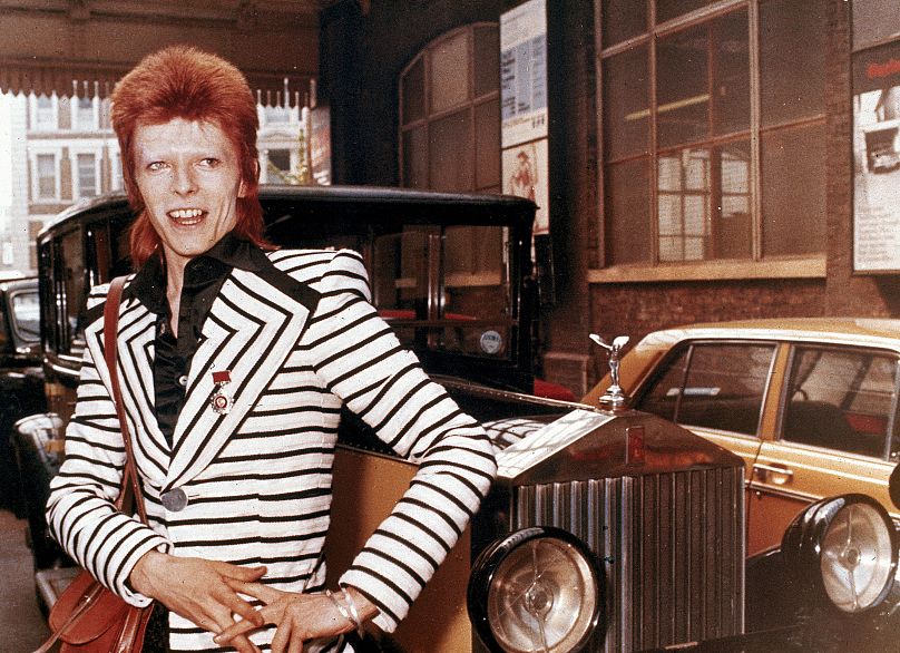 Le chanteur de rock britannique David Bowie pose à côté de sa vieille voiture Rolls Royce avant de partir pour le début d'une tournée britannique, le 15 mai 1973.