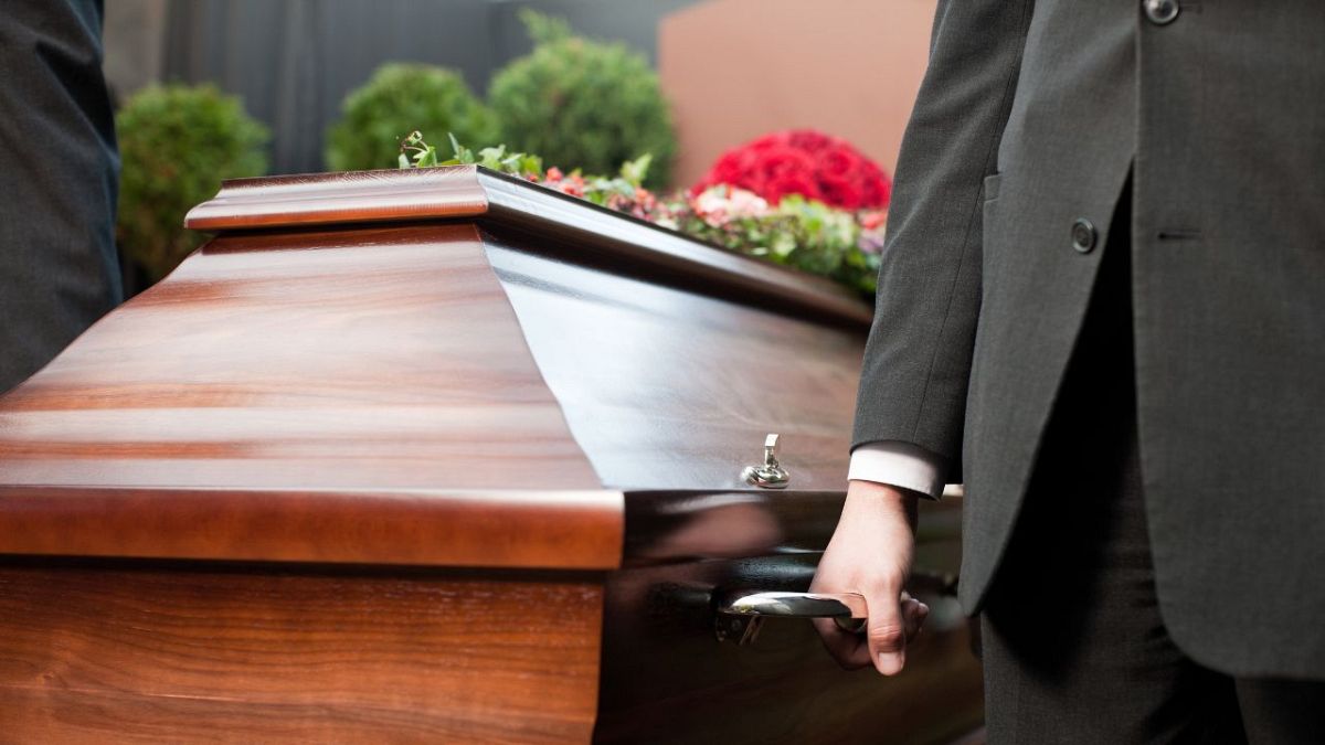 A man carries a coffin.