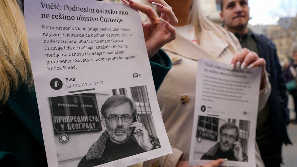 Media rights groups and opposition campaigners hold leaflets showing journalist Slavko Curuvija during a protest in front of Serbian appeals court, in Belgrade, Serbia
