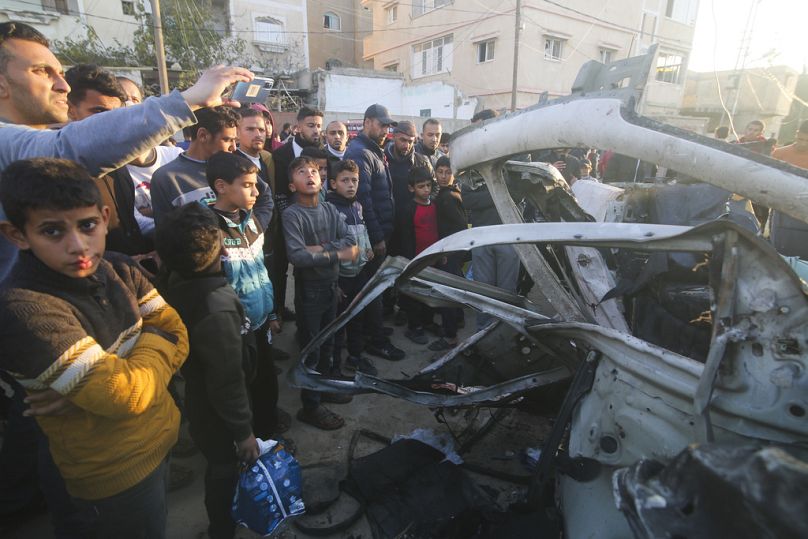 Des Palestiniens se rassemblent autour d'un véhicule de police du Hamas après qu'il a été touché par une frappe aérienne israélienne à Rafah, dans la bande de Gaza.