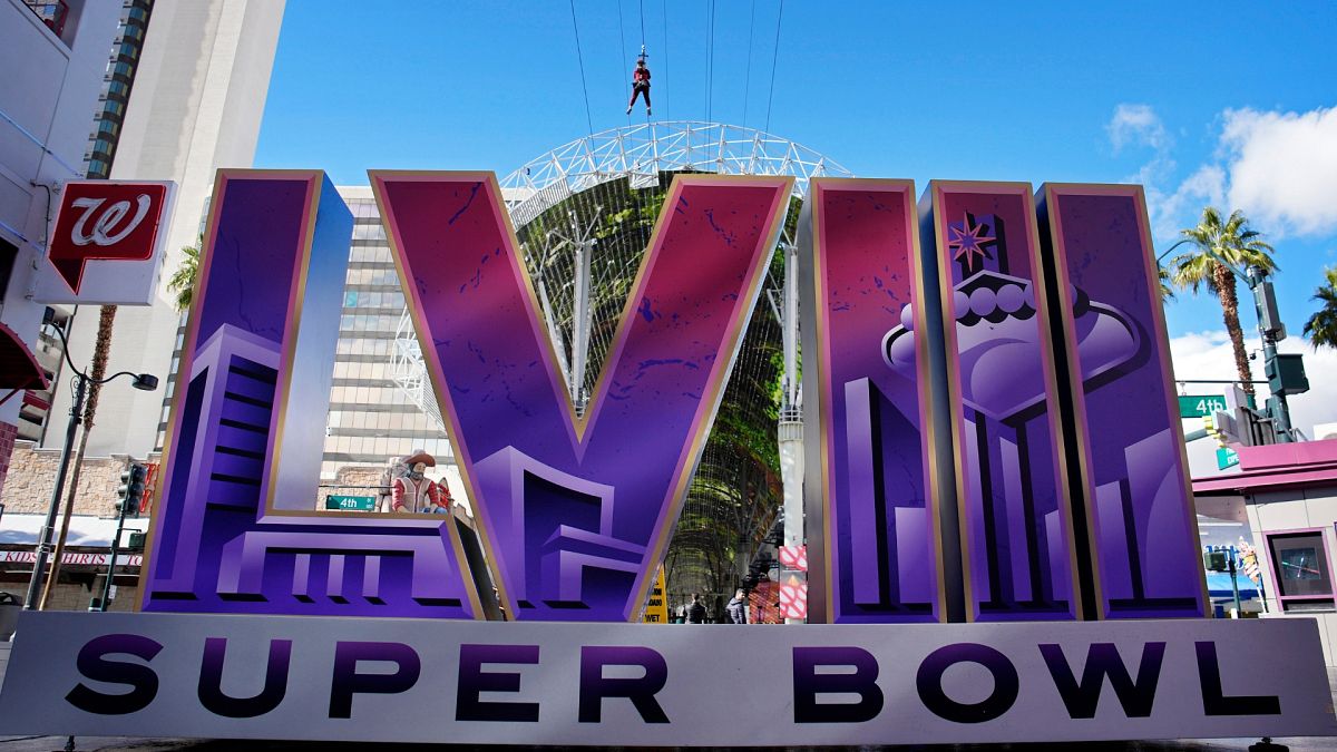 People ride a zip line above a sign for the Super Bowl ahead of the Super Bowl 58 NFL football game, Friday, Feb. 2, 2024