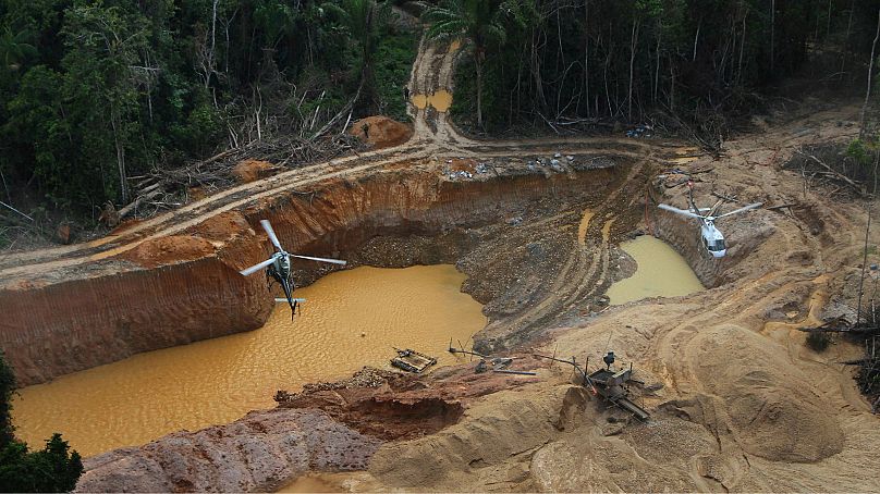 Un hélicoptère de l'Agence brésilienne pour l'environnement survole un camp minier illégal sur le territoire autochtone Yanomami, dans l'État de Roraima, au Brésil, le 11 février 2023.