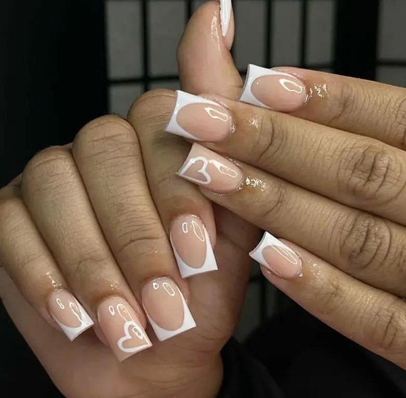 Un exemple d'ongles carrés courts français avec des coeurs d'amour