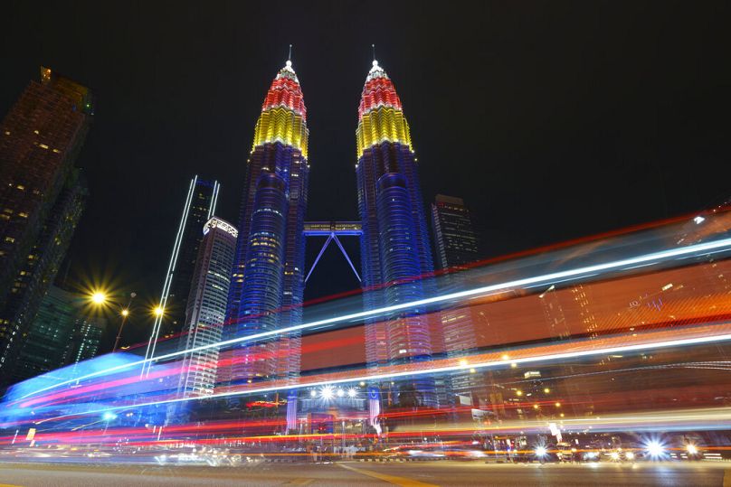 Tours jumelles Petronas décorées de lumières colorées lors des célébrations de la 64e Fête nationale pour commémorer l'indépendance de la Malaisie, à Kuala Lumpur, août 2021