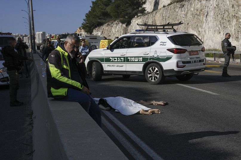 Les forces de sécurité israéliennes se tiennent à côté du corps d’un attaquant palestinien, recouvert d’un sac en plastique, sur le site d’une fusillade en Cisjordanie.