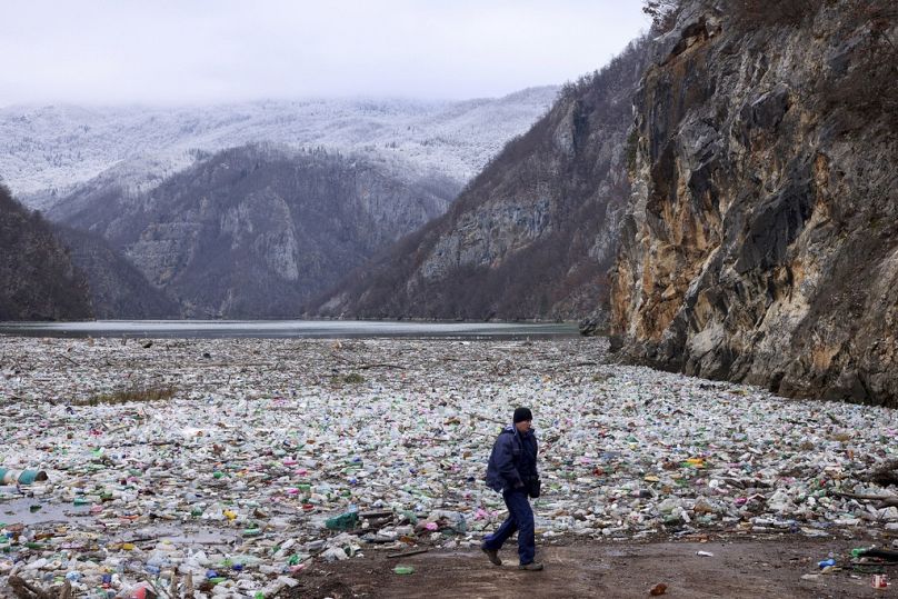 Un grutier marche à côté de la base de déchets dans la rivière Drina, près de Visegrad, en Bosnie.