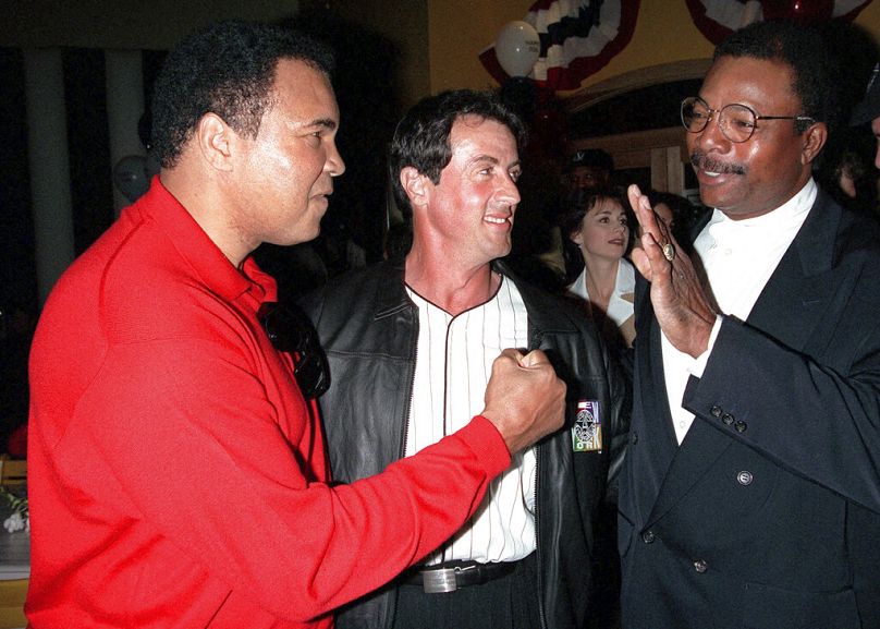 L'ancien champion de boxe poids lourd Muhammad Ali, à gauche, rejoint Sylvester Stallone et Carl Weathers lors de l'événement du 20e anniversaire de 