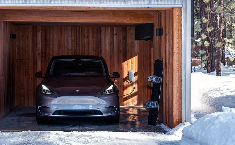 Une Tesla Model Y en charge à domicile sous abri pendant l'hiver.
