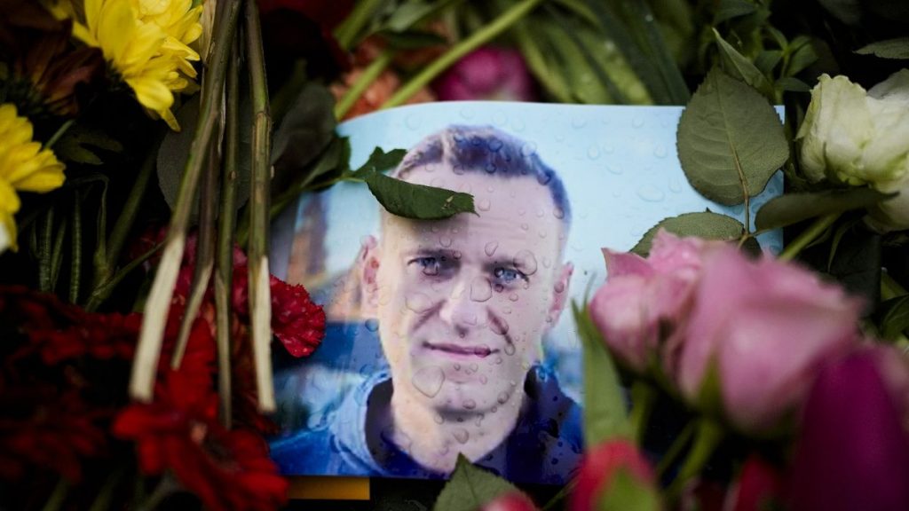 Rain drops cover a portrait of Russian opposition leader Alexei Navalny, placing between flowers in front of the Russian embassy in Berlin, Feb. 21, 2024.