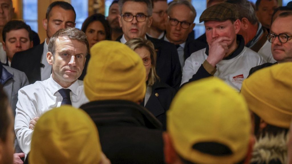 French President Emmanuel Macron, left, speaks with farmers as he visits the International Agriculture Fair on the opening day in Paris, Feb. 24, 2024.
