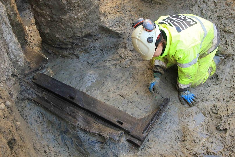 Un archéologue fouille le lit en bois découvert à Londres