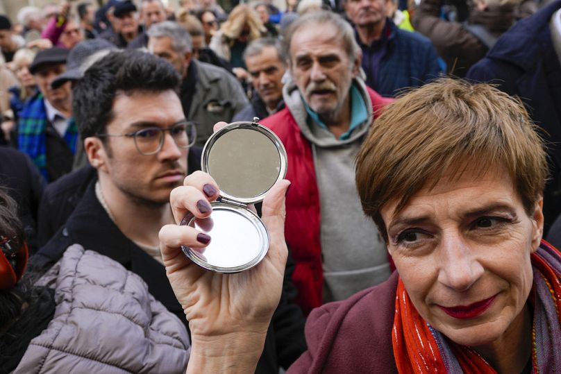 Des groupes de défense des droits des médias et des militants de l'opposition tiennent des miroirs lors d'une manifestation devant la cour d'appel serbe à Belgrade.