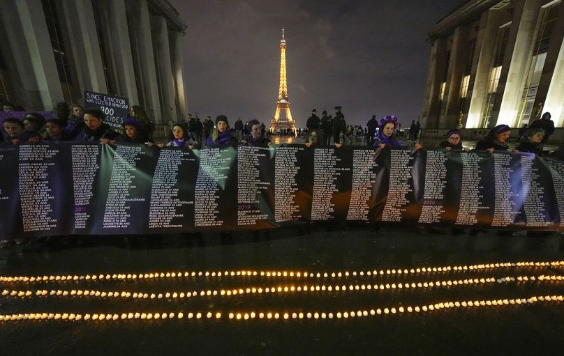 Des membres du groupe de femmes #NousToutes tiennent une banderole avec les noms des 900 femmes tuées par leurs partenaires sur la place du Trocadéro près de la Tour Eiffel, le jeudi 8 février 2024.
