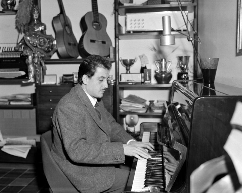 Le compositeur et chanteur italien Domenico Modugno joue du piano chez lui à Rome, en Italie, le 7 novembre 1958.