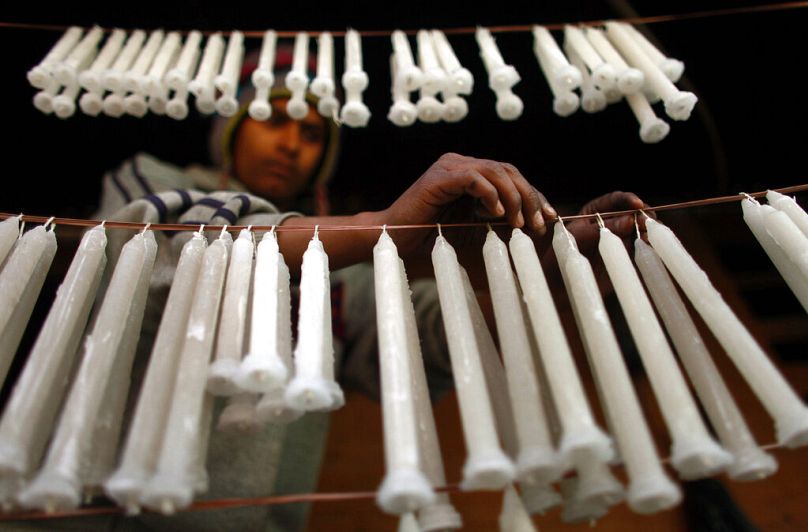 Un Népalais accroche des bougies pour les faire sécher, à Katmandou, décembre 2011.