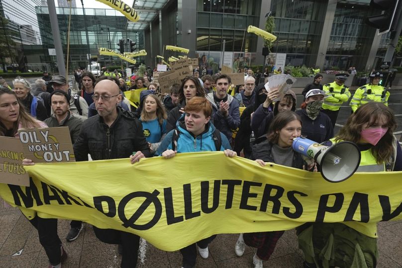 Des militants écologistes, dont Greta Thunberg, au centre gauche, défilent avec d'autres manifestants lors de la manifestation Oily Money Out à Canary Wharf, à Londres.