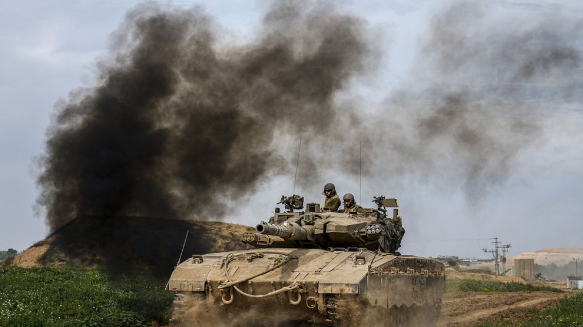 Israeli soldiers drive an tanks on the border with the Gaza Strip, in southern Israel, Tuesday, Feb. 13, 2024.