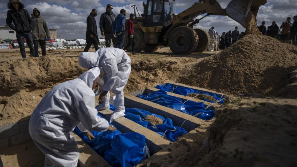Palestinians bury the bodies of people who were killed in fighting with Israel and returned to Gaza by the Israeli military, during a mass funeral in Rafah, Gaza on Tuesday