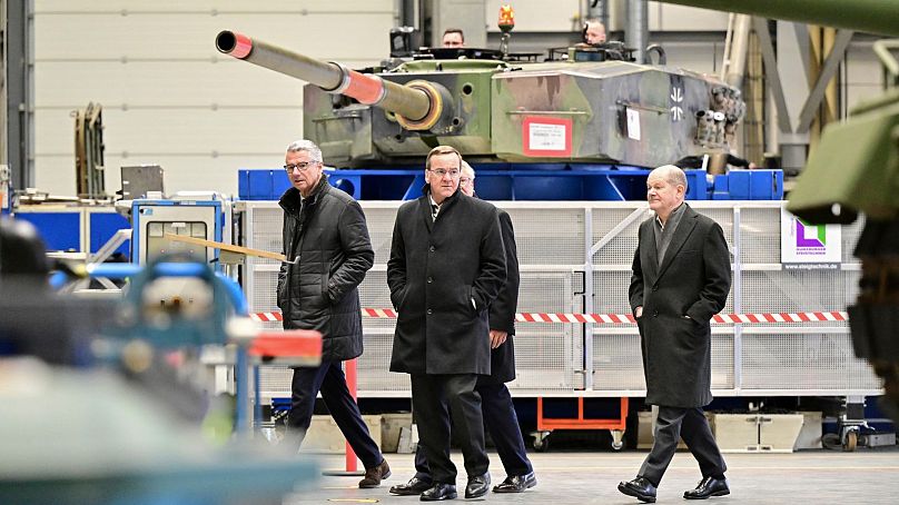 Le chancelier allemand Olaf Scholz, à droite, et Boris Pistorius, ministre fédéral de la Défense, inspectent un hall de production de véhicules blindés du groupe d'armement Rheinmetall.