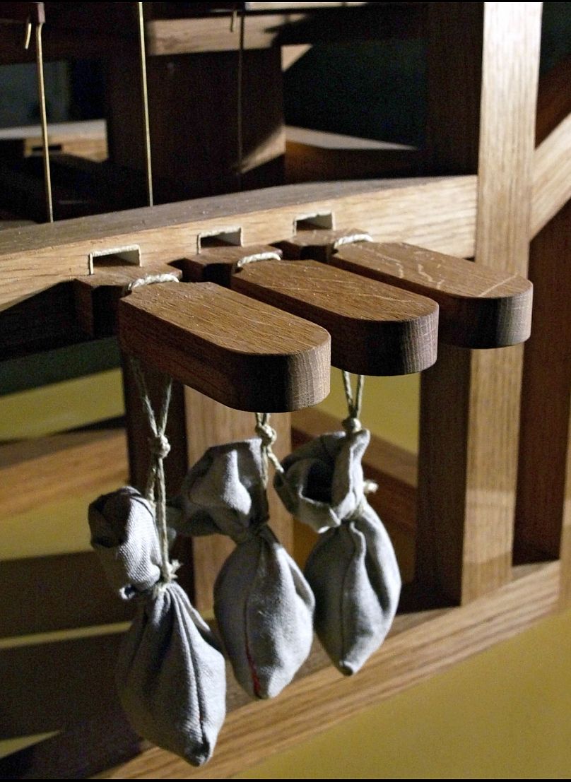 De petits sacs de sable sont placés sur les touches pour maintenir la même note jusqu'à ce qu'il soit temps de jouer l'accord suivant.