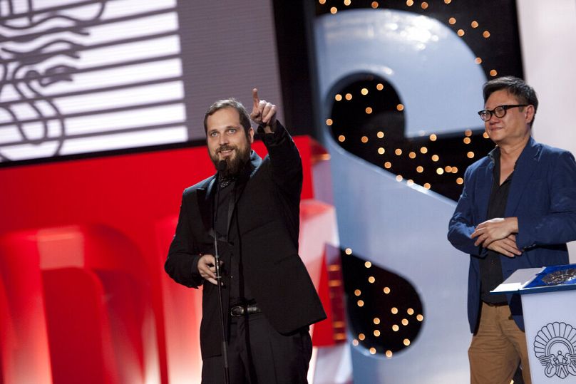 Le réalisateur espagnol Carlos Vermut, à gauche, fait des gestes après avoir reçu du membre du jury officiel, Erik Khoo de Singapour, la Coquille d'Argent du meilleur réalisateur.