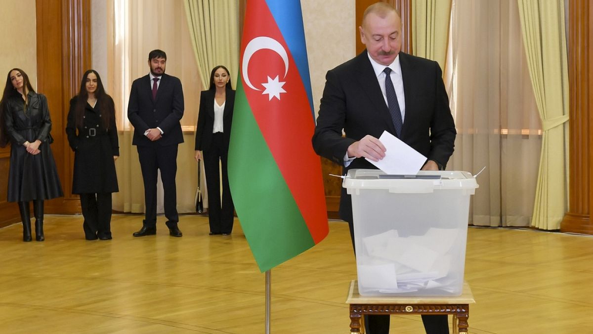 Azerbaijan President Ilham Aliyev casts his ballot as his family members stand near during presidential election at a polling station in Khankendi, Karabakh.