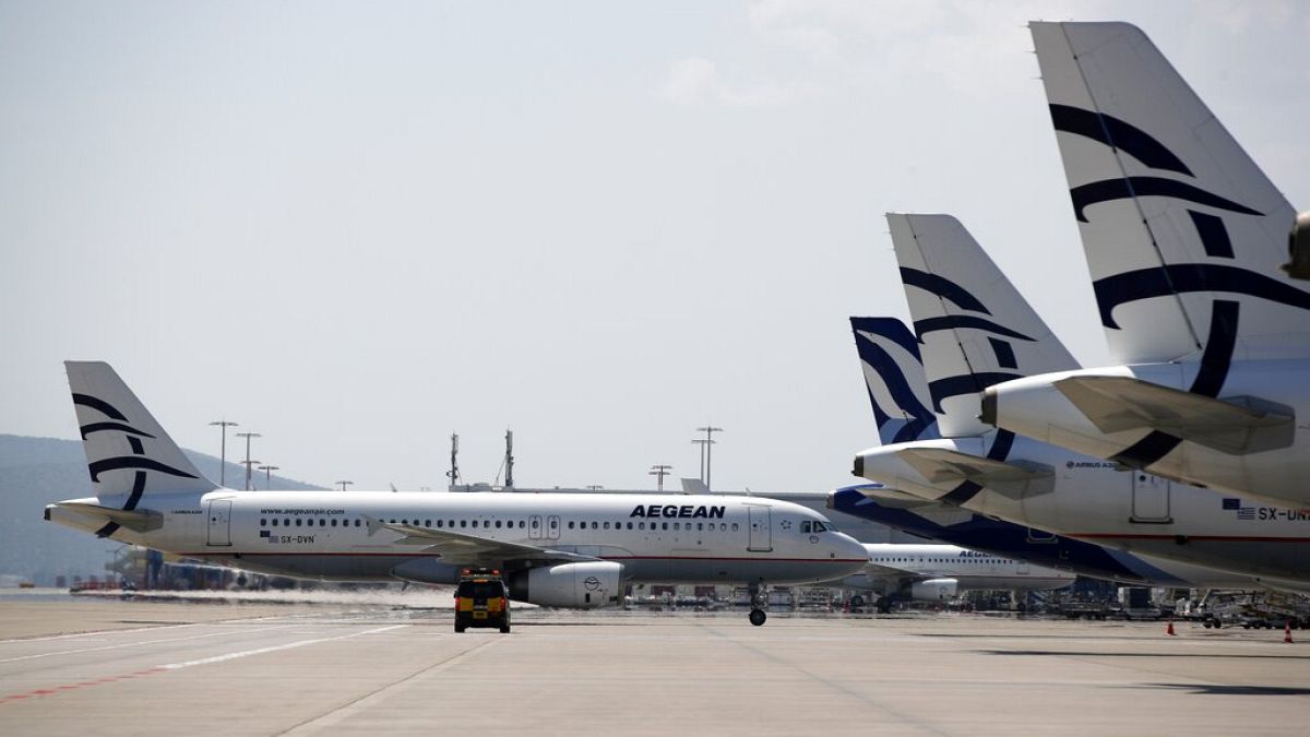 An aircraft of Aegean Airlines approaching the terminal as others planes are parked at Eleftherios Venizelos International Airport in Athens, Tuesday, March 31, 2020.