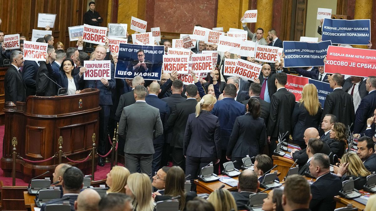 Opposition lawmakers hold banners reading: "Stole the elections" during a Serbia