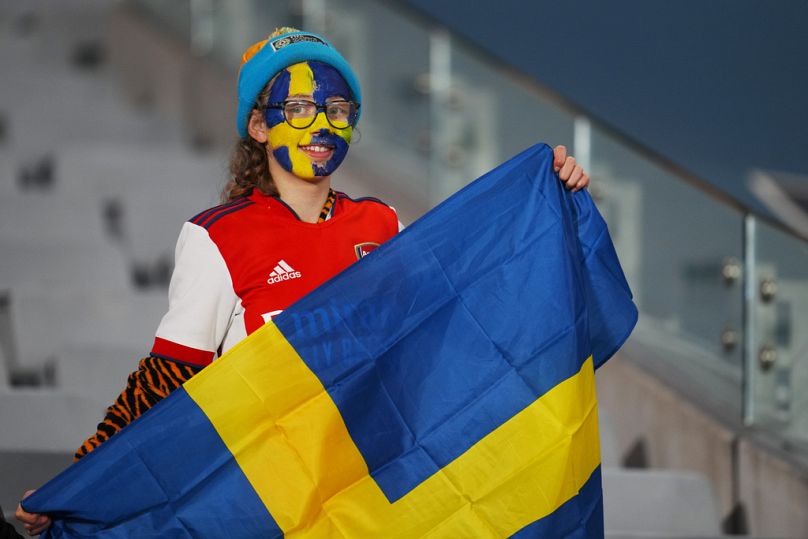 Un jeune fan tient un drapeau suédois sur les tribunes avant le match de football quart de finale de la Coupe du monde féminine entre le Japon et la Suède à Eden Park à Auckland, en Nouvelle-Zélande.