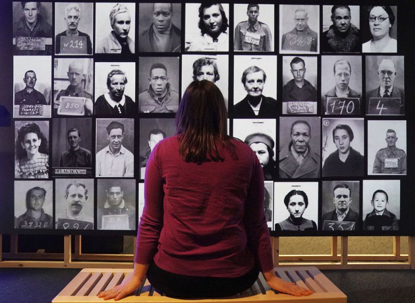Un membre du personnel observe un affichage numérique présentant des photos d'identification de prisonniers de guerre et d'internés étrangers, qui font partie de l'exposition « Great Escapes » aux Archives nationales.