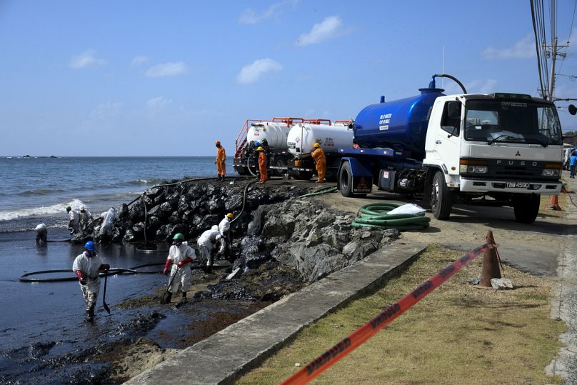 Des travailleurs de la société nationale Heritage Petroleum Oil and Gas Company nettoient une marée noire dans le sud-ouest de Tobago.