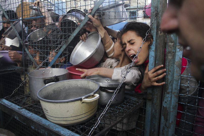 Des Palestiniens font la queue pour recevoir des repas gratuits au camp de réfugiés de Jabaliya, dans la bande de Gaza, le lundi 18 mars 2024.