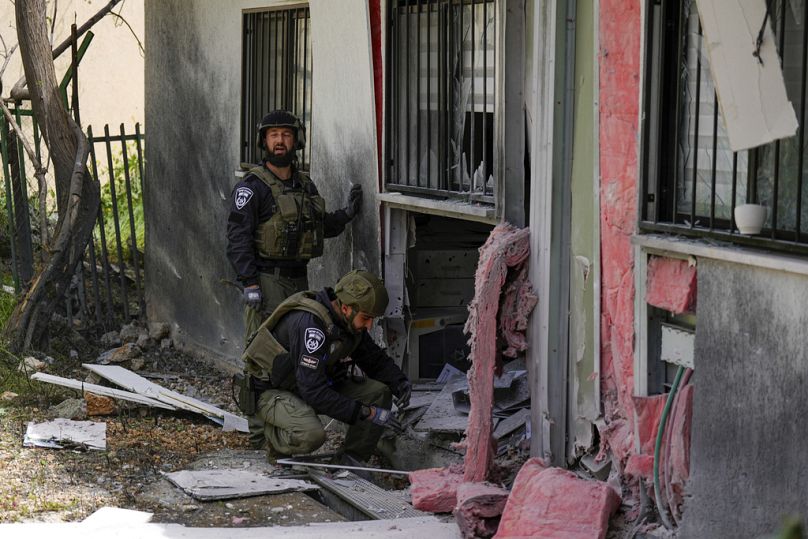 Les forces de sécurité israéliennes examinent le site touché par une roquette tirée depuis le Liban, à Kiryat Shmona, mars 2024.