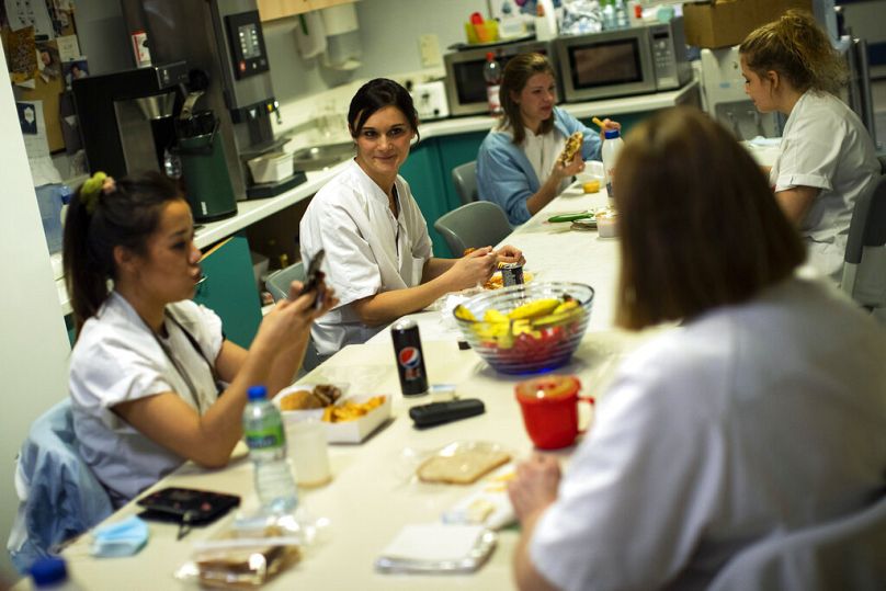 Une infirmière discute avec des collègues lors d'une pause dîner dans le service de soins intensifs pour patients COVID-19 d'un hôpital de Liège, décembre 2020.