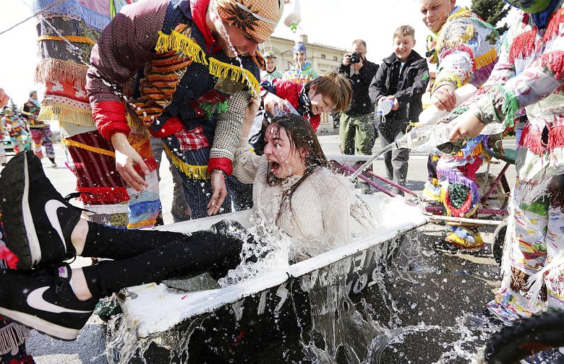 Une fille est aspergée d'eau par des garçons suivant une tradition polonaise du lundi de Pâques humide, à Wilamowice, en Pologne, le lundi 17 avril 2017.