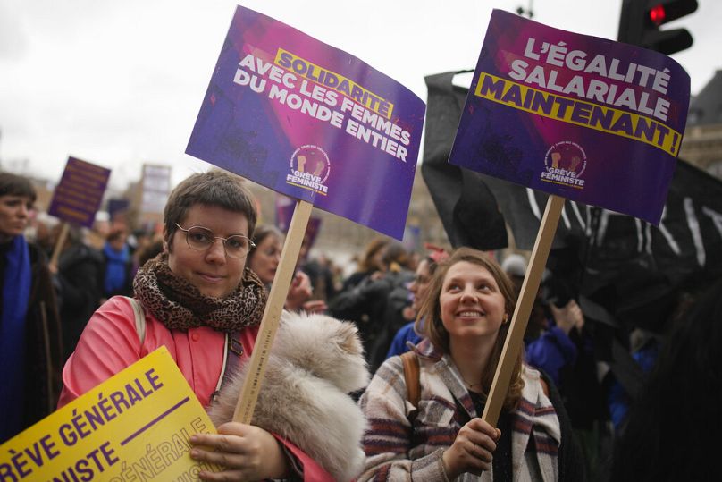 Les femmes manifestent avec des affiches lisant "L'égalité de salaire maintenant"c'est vrai, et "Solidarité avec les femmes du monde entier" dans le cadre de la Journée Internationale des Femmes à Paris, mars 2023