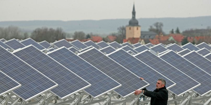 Un homme vérifie des modules solaires sur un toit à Soemmerda, novembre 2008